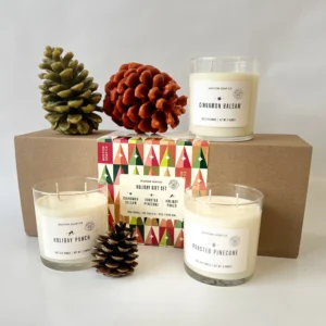 Set of festive hand-poured candles in holiday-inspired scents with seasonal packaging.