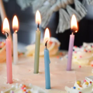 Hand-poured Birthday Candle in a glass jar surrounded by colorful confetti and sprinkles.