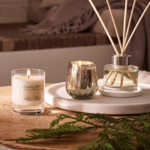 Hand-poured Incense Candle burning beside sandalwood sticks and soft ambient lighting.